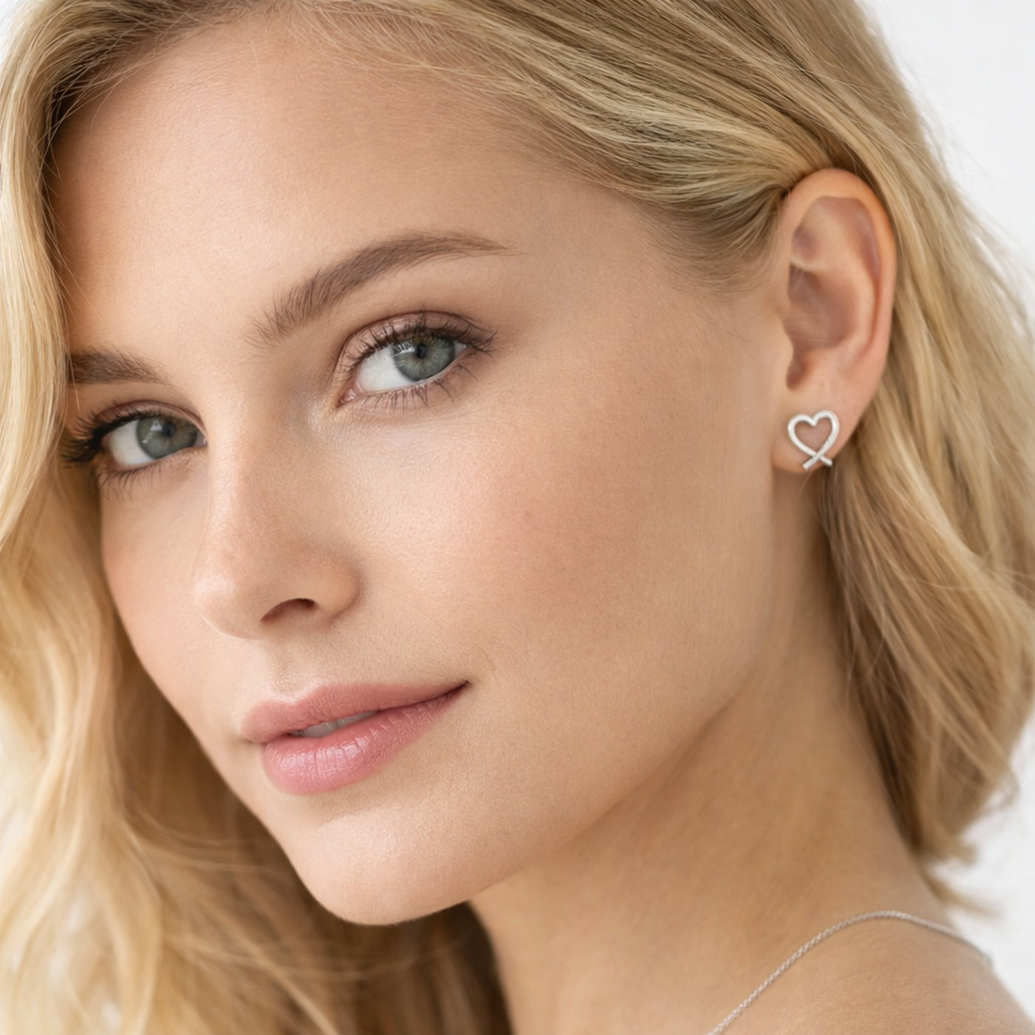 Melchior Jewellery sterling silver heart stud earrings worn by woman with blonde hair