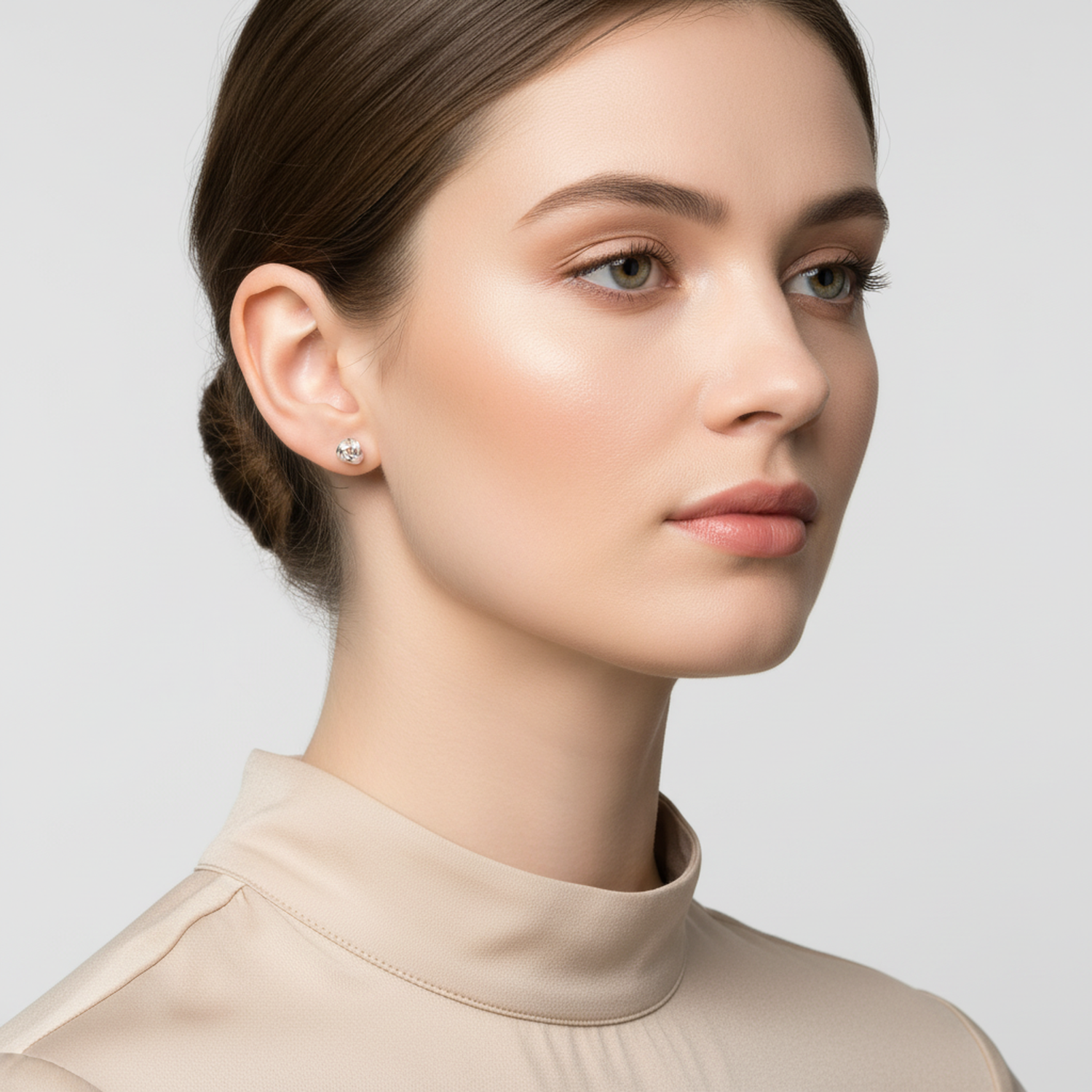 Melchior Jewellery sterling silver knot stud earrings worn by woman with neutral makeup and beige top