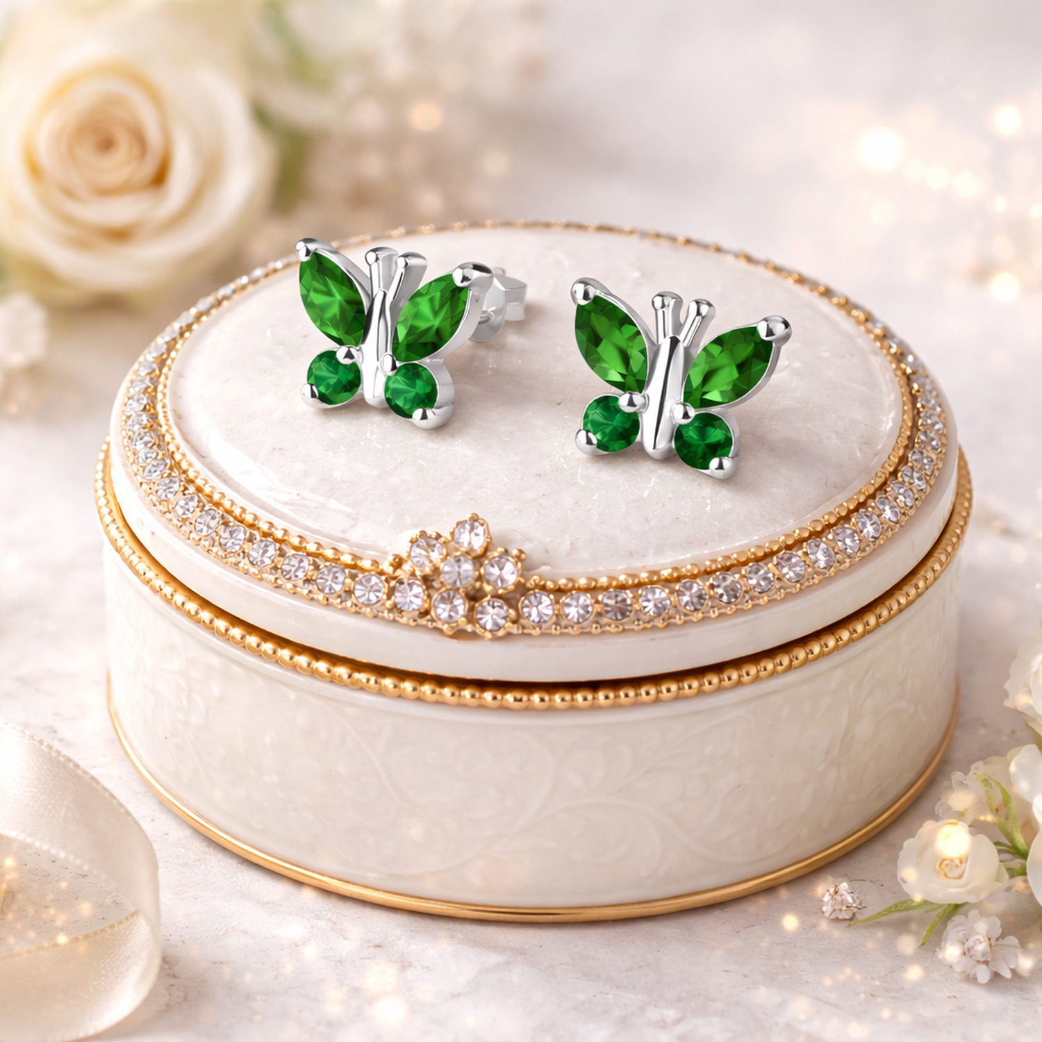 Sterling silver May birthstone earrings by Melchior Jewellery shaped as green butterfly studs on decorative jewellery box