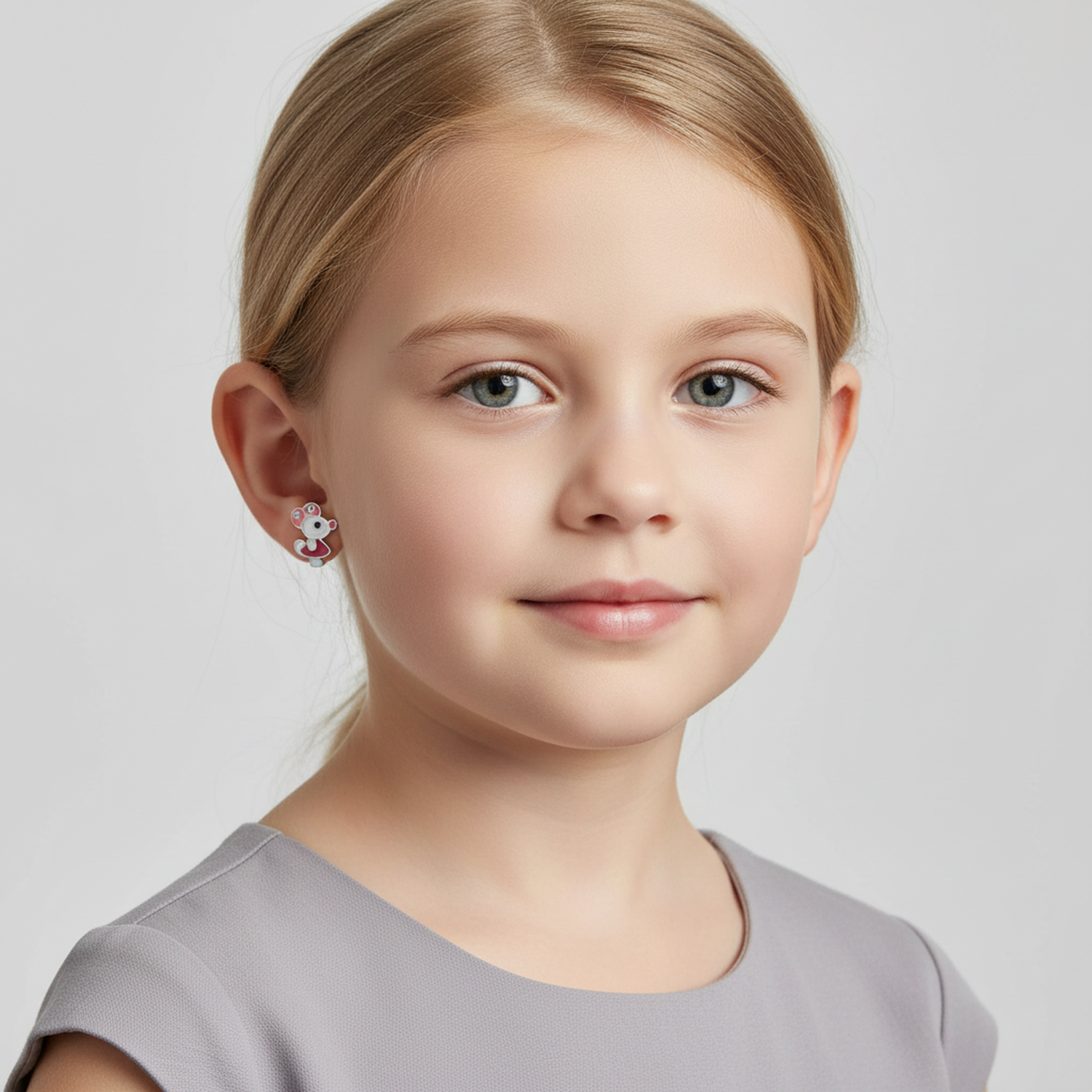 Child wearing Melchior Jewellery sterling silver mouse studs for girls in a close-up portrait