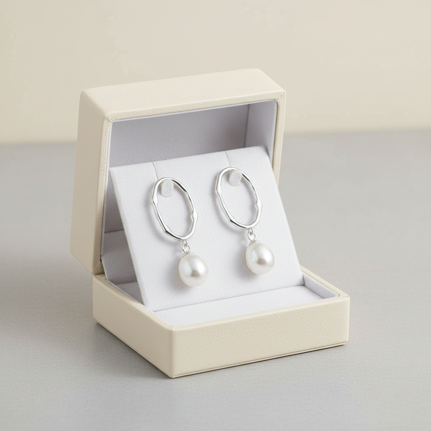 Sterling silver pearl drop earrings from Melchior Jewellery displayed in a cream jewellery box