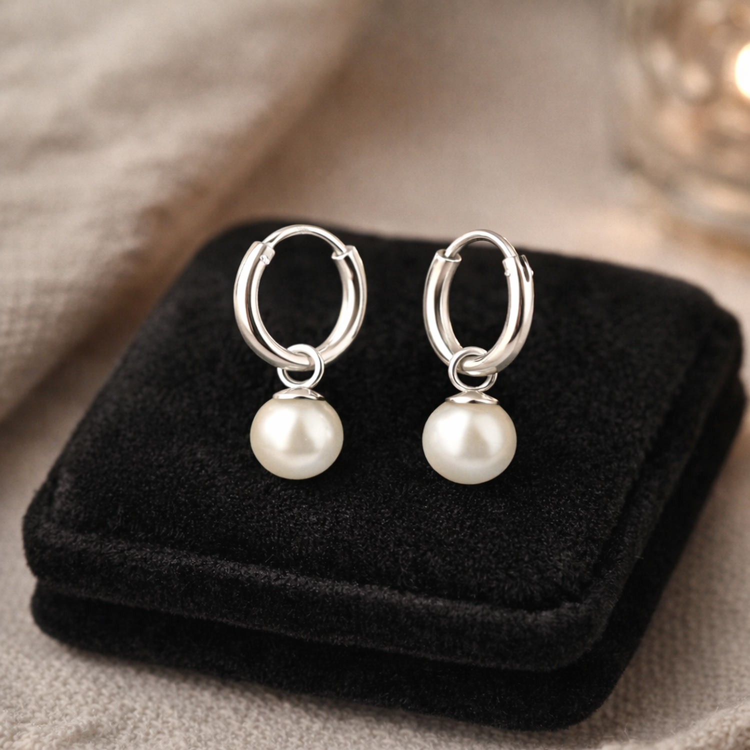 Melchior Jewellery sterling silver pearl hoop earrings displayed on black velvet cushion