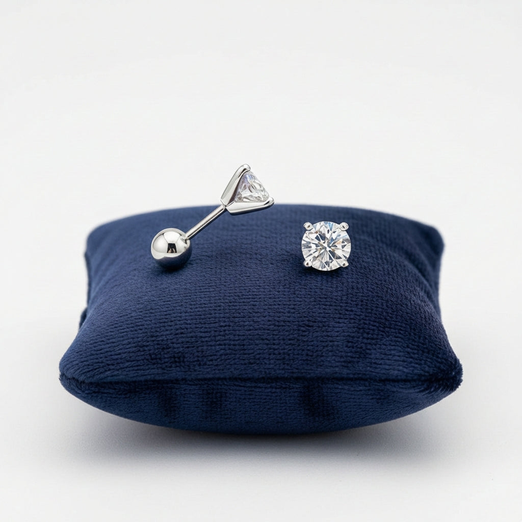 Sterling silver screw back earrings for children with clear round stones displayed on navy cushion