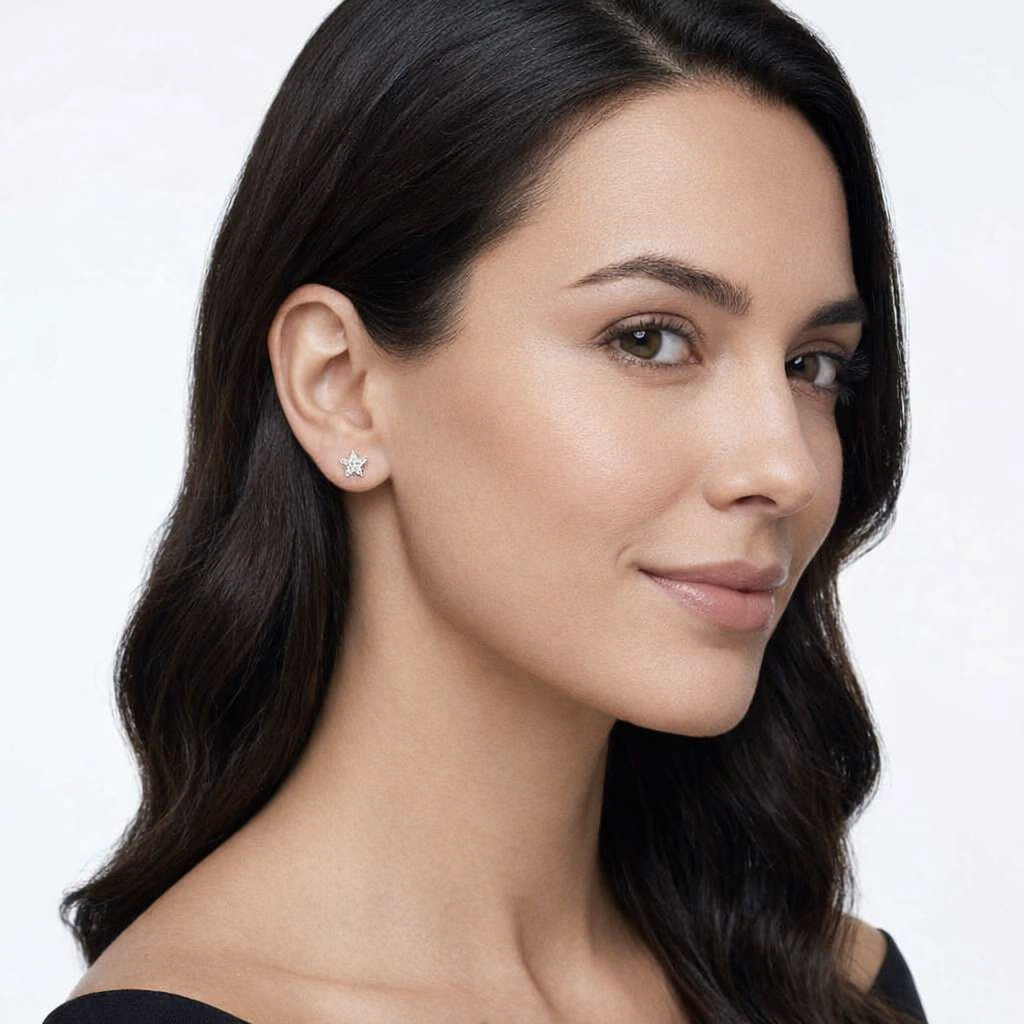 Woman wearing delicate sterling silver star stud earrings by Melchior Jewellery with a polished finish