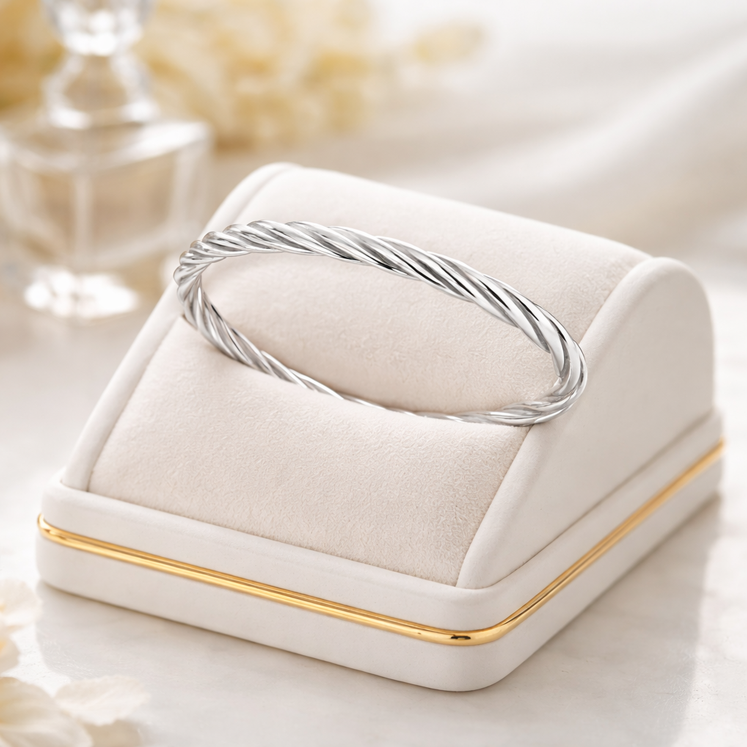 Melchior Jewellery sterling silver twisted bangle displayed on a white cushion with gold trim