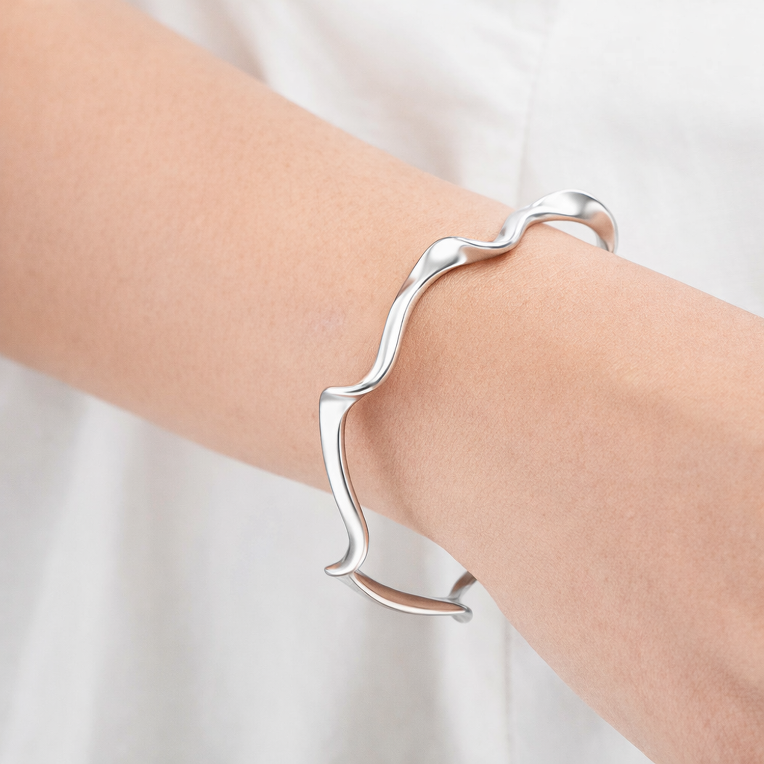 Melchior Jewellery sterling silver wave cuff bangle worn on wrist with smooth fluid design