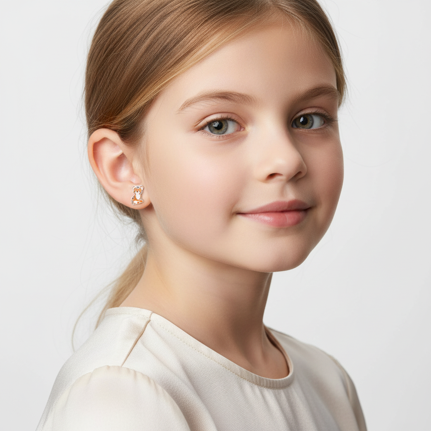 Melchior Jewellery tiger stud earrings for children worn by young girl with light hair and white top