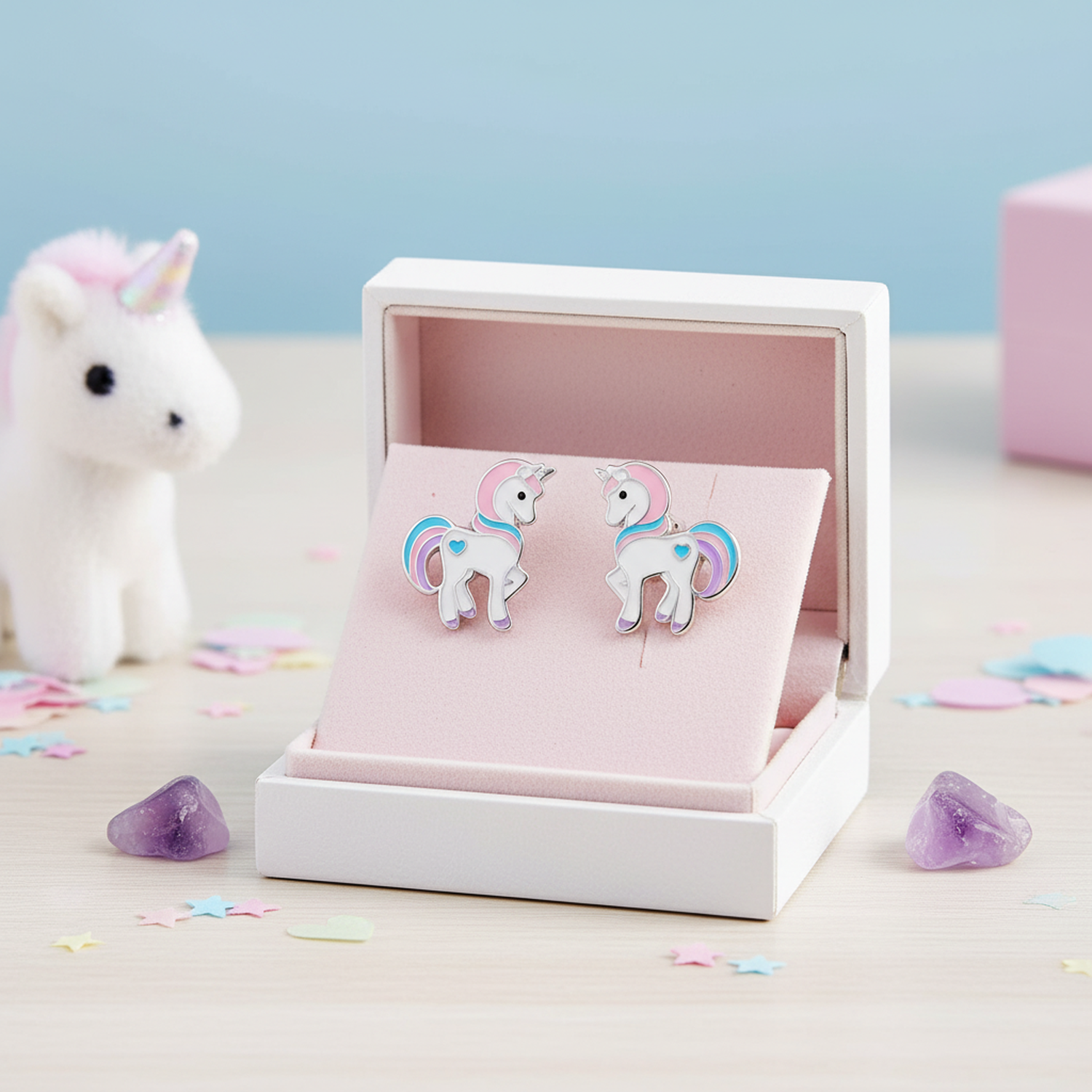 Melchior Jewellery unicorn stud earrings for girls featuring white unicorns with pink and blue manes in a white gift box with pastel decorations