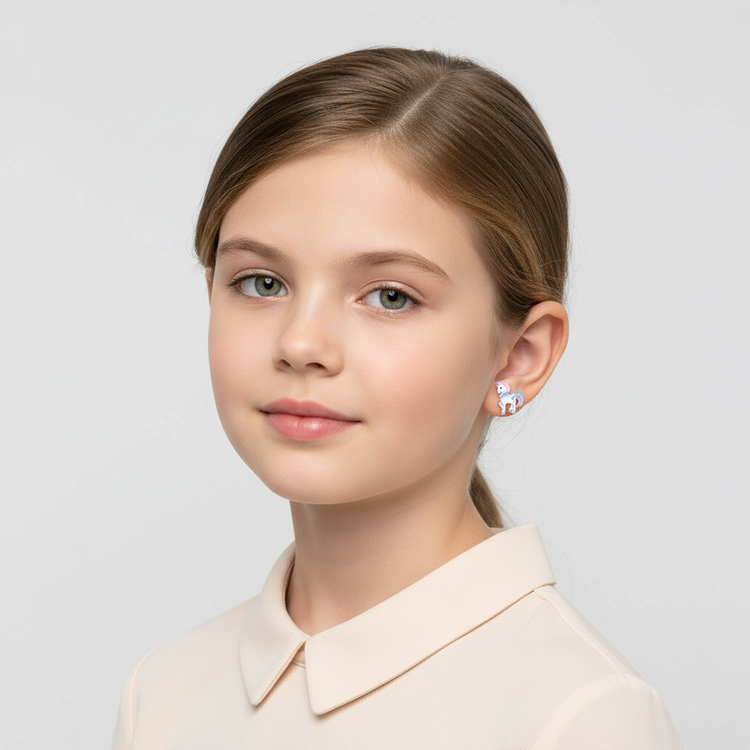 Girl wearing Melchior Jewellery unicorn stud earrings for girls in white and pink design