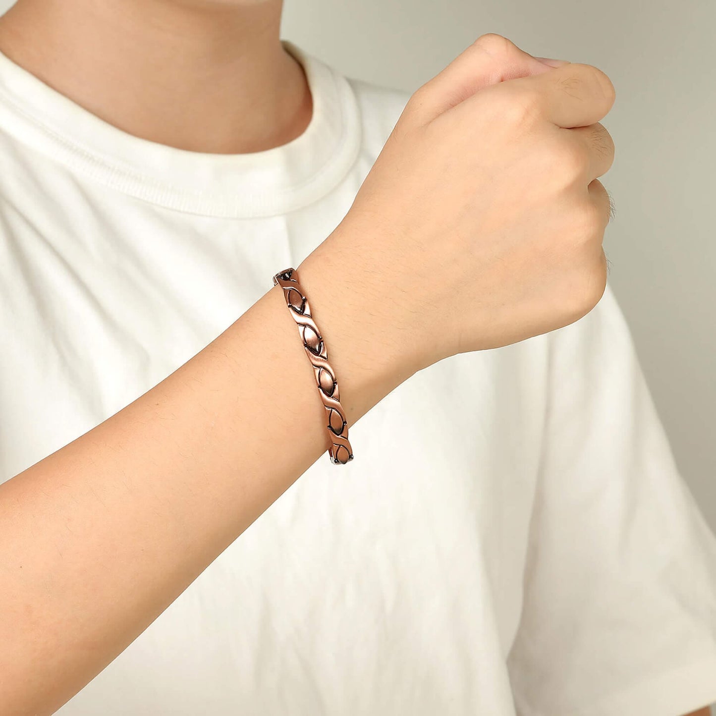 Melchior Jewellery womens copper magnetic bracelet on wrist with linked leaf design worn with white tee