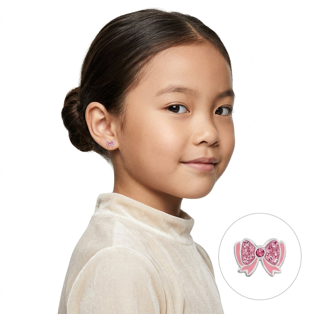 Pink crystal bow earrings for girls worn by a child, featuring sparkling light pink crystals and a central pink gem