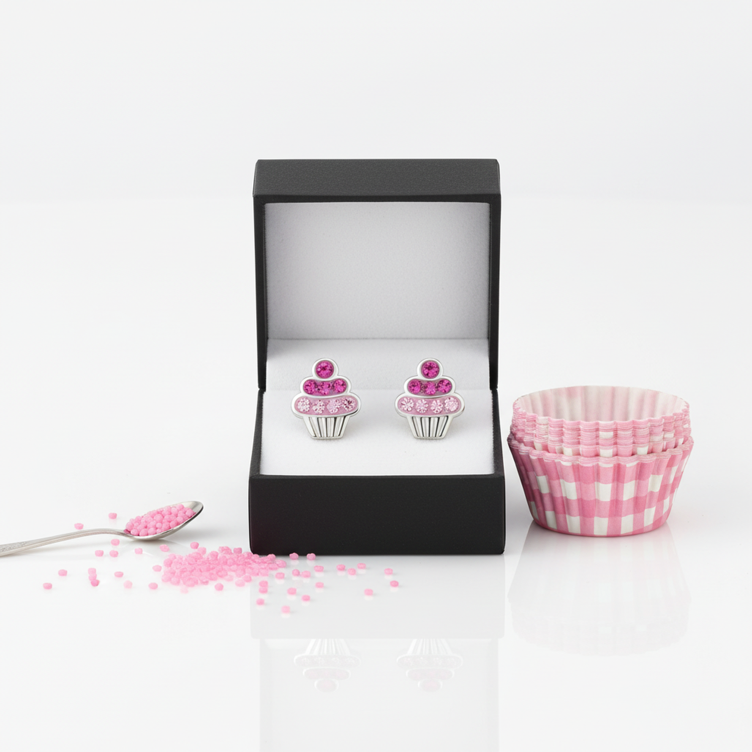 Pink cupcake earrings for children by Melchior Jewellery displayed in black box with pink cupcake cases and small pink sprinkles