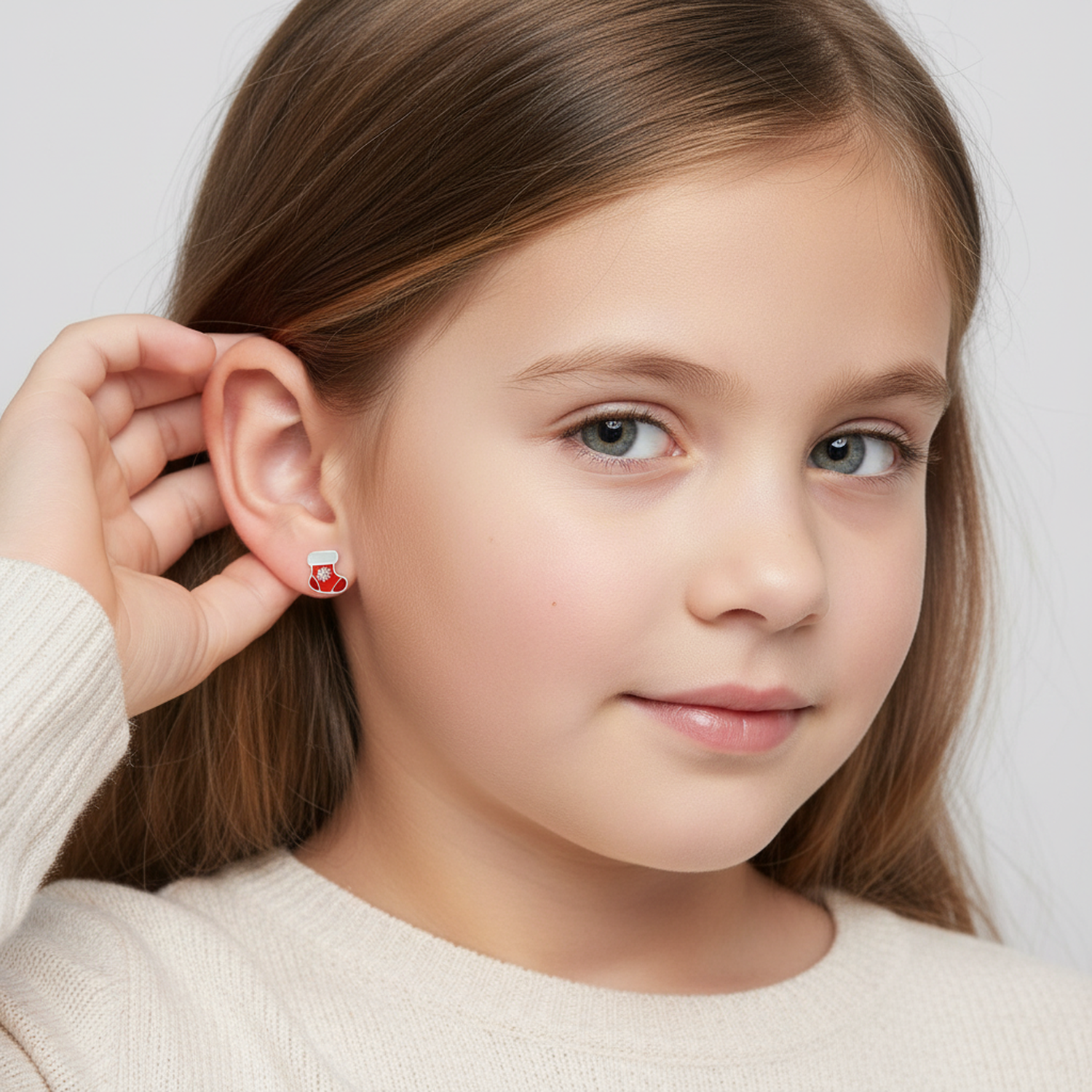 Melchior Jewellery kids Christmas stocking stud earrings worn by a young girl with long hair