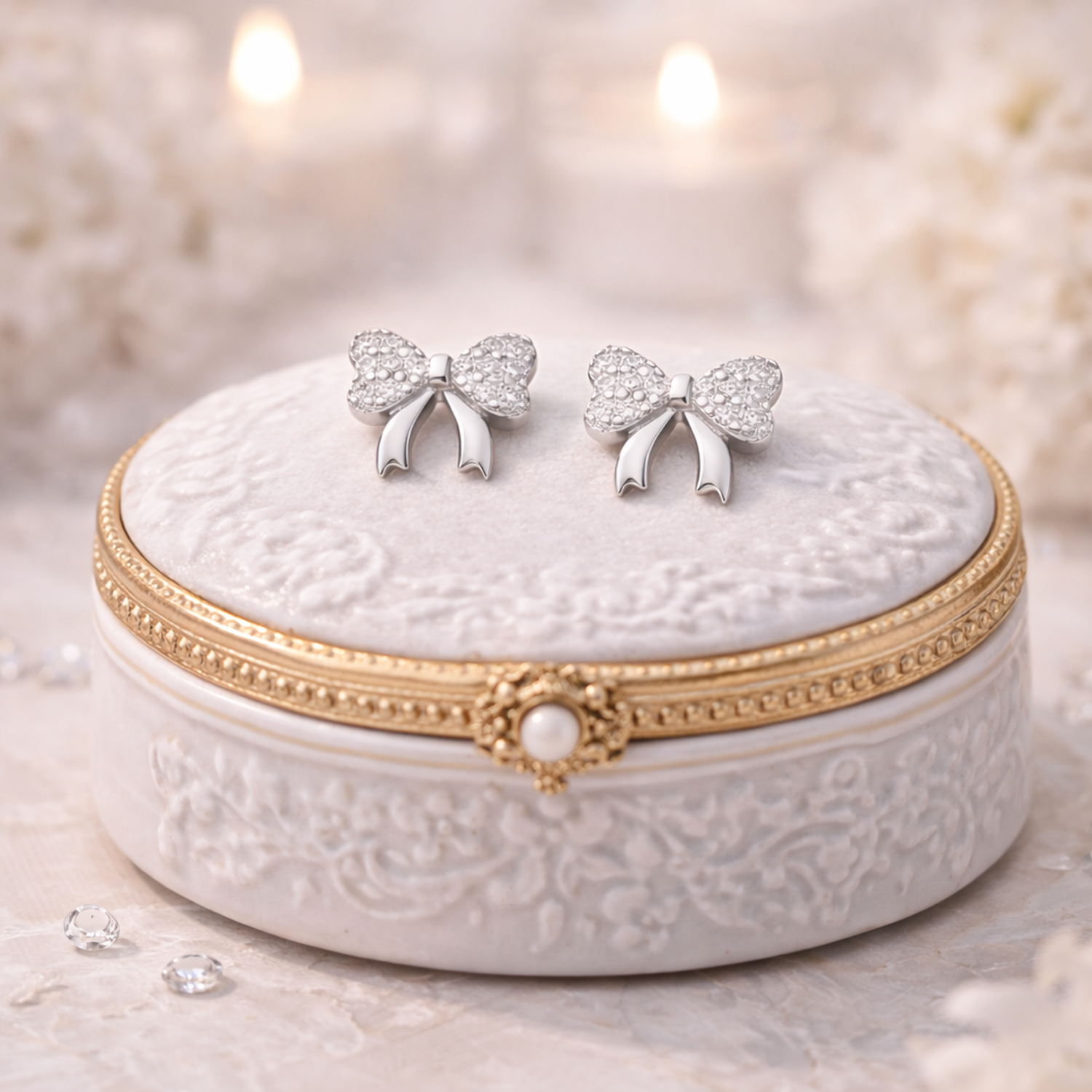Sterling silver bow stud earrings by Melchior Jewellery displayed on decorative white and gold jewellery box