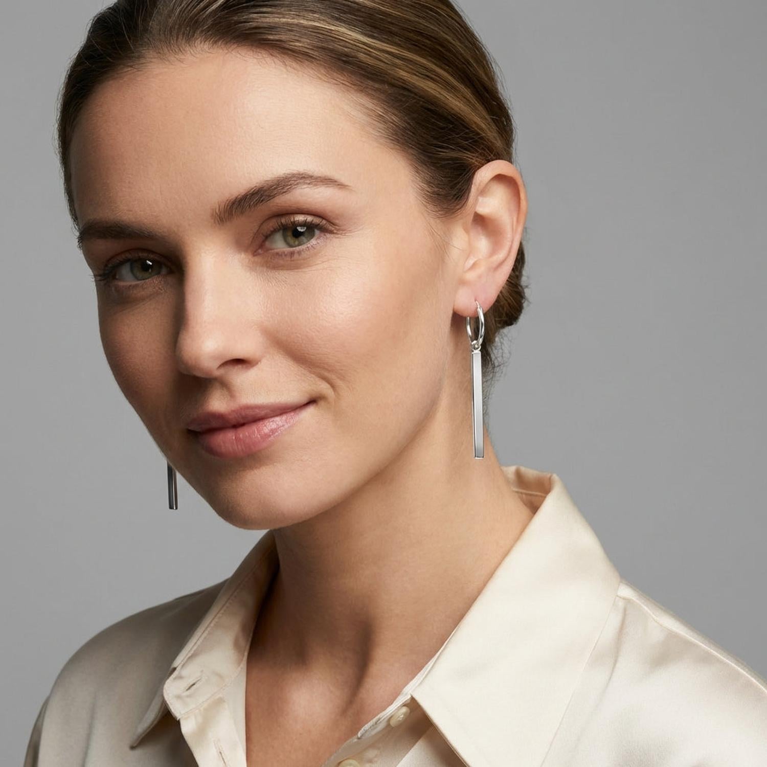 Melchior Jewellery sterling silver bar charm hoop earrings worn by woman with cream shirt