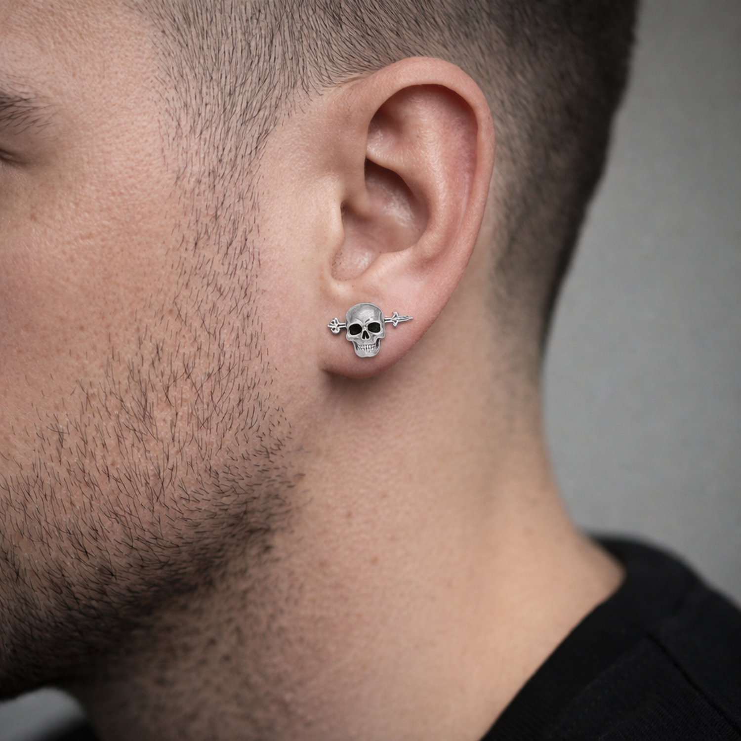 Single skull earring for men by Melchior Jewellery worn on male ear with short hair