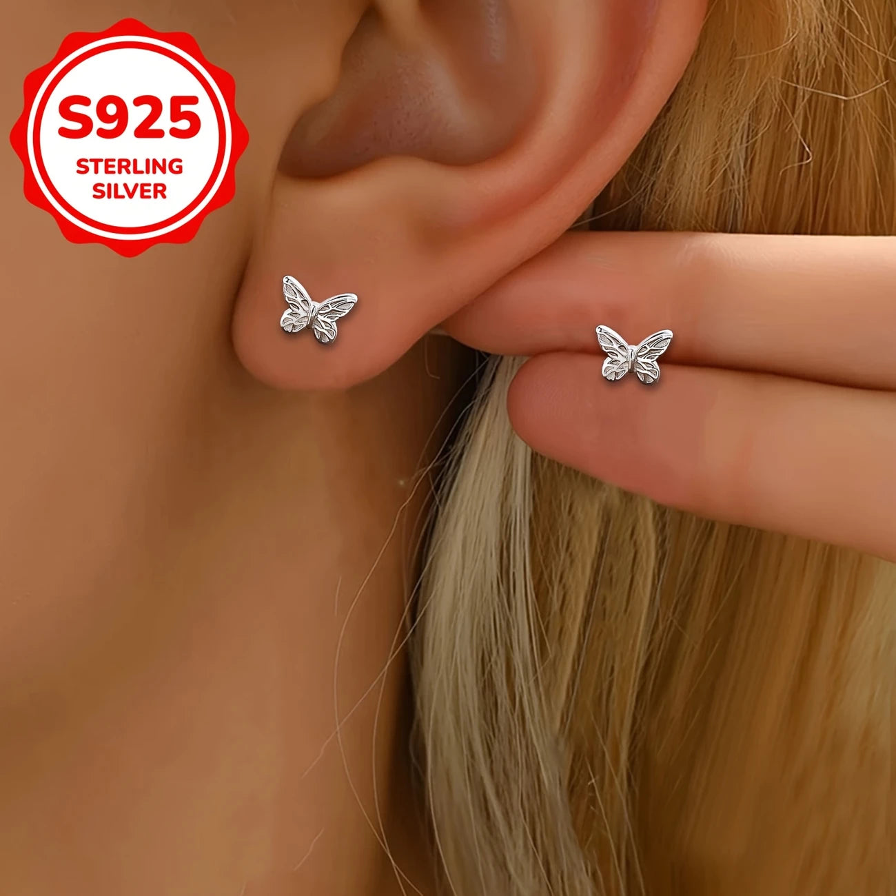 Melchior Jewellery small butterfly screw back earrings in sterling silver worn on a child’s ear