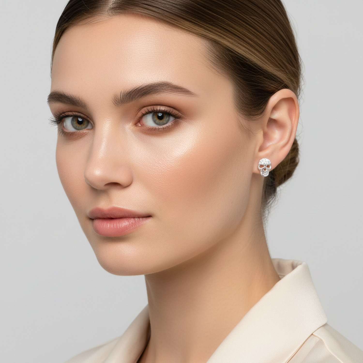 Melchior Jewellery sterling silver skull stud earrings worn by woman with neutral makeup