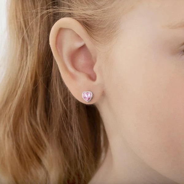 Heart-shaped pink stud earrings showcased on a model's ear.