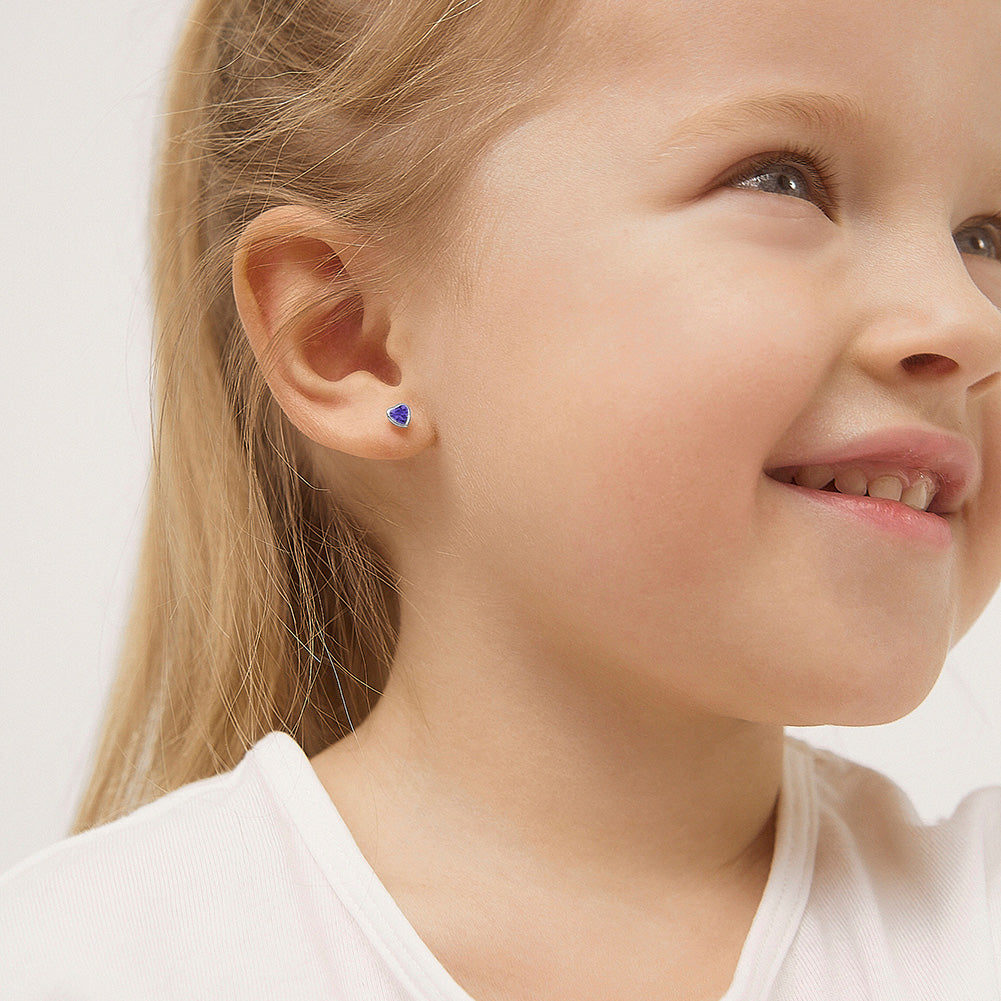 14k white gold baby girl earrings with blue heart-shaped stones worn by a smiling child