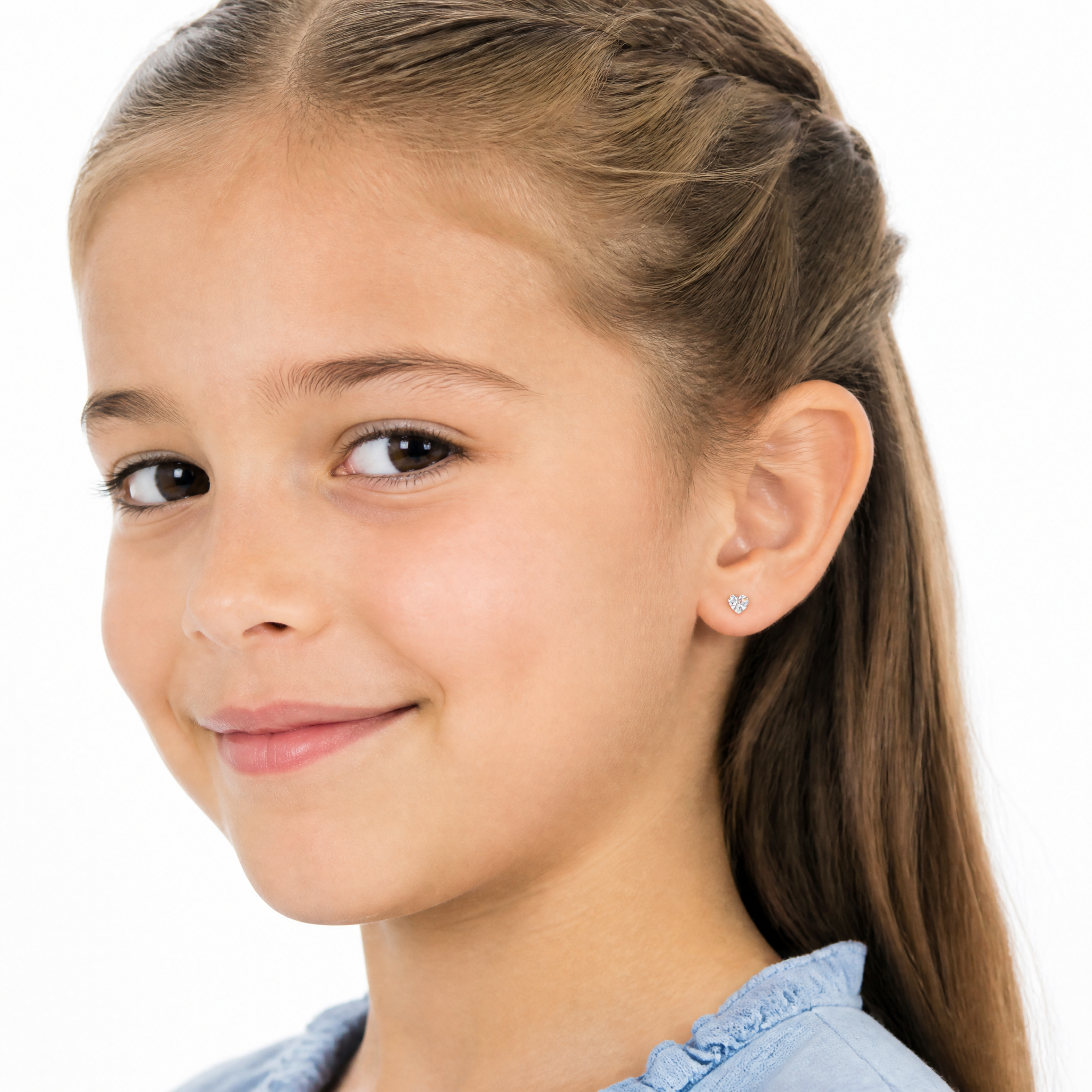 A young girl with light brown hair in a side braid wearing a small silver stud earring, shown in a close-up portrait against a white background.