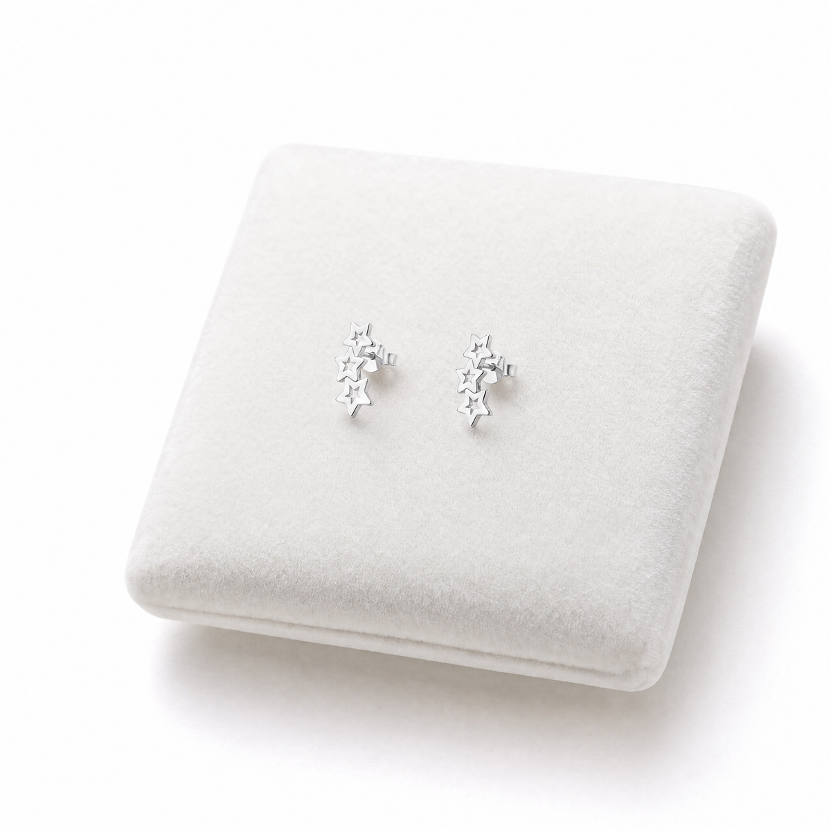 Sterling silver triple star stud earrings on Jewellery cushion