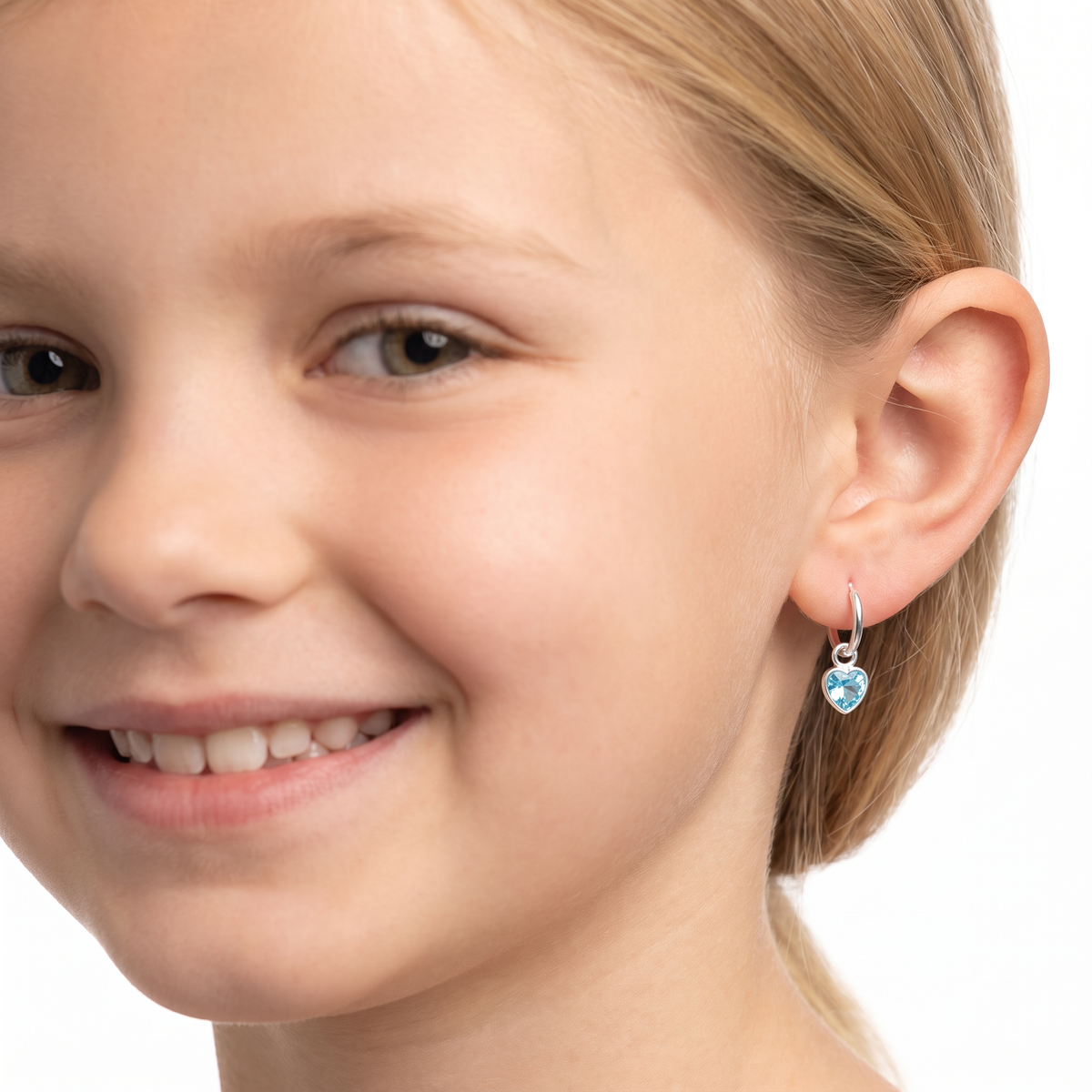Close-up of aqua-blue heart-shaped cubic zirconia charms on sterling silver hoop earrings