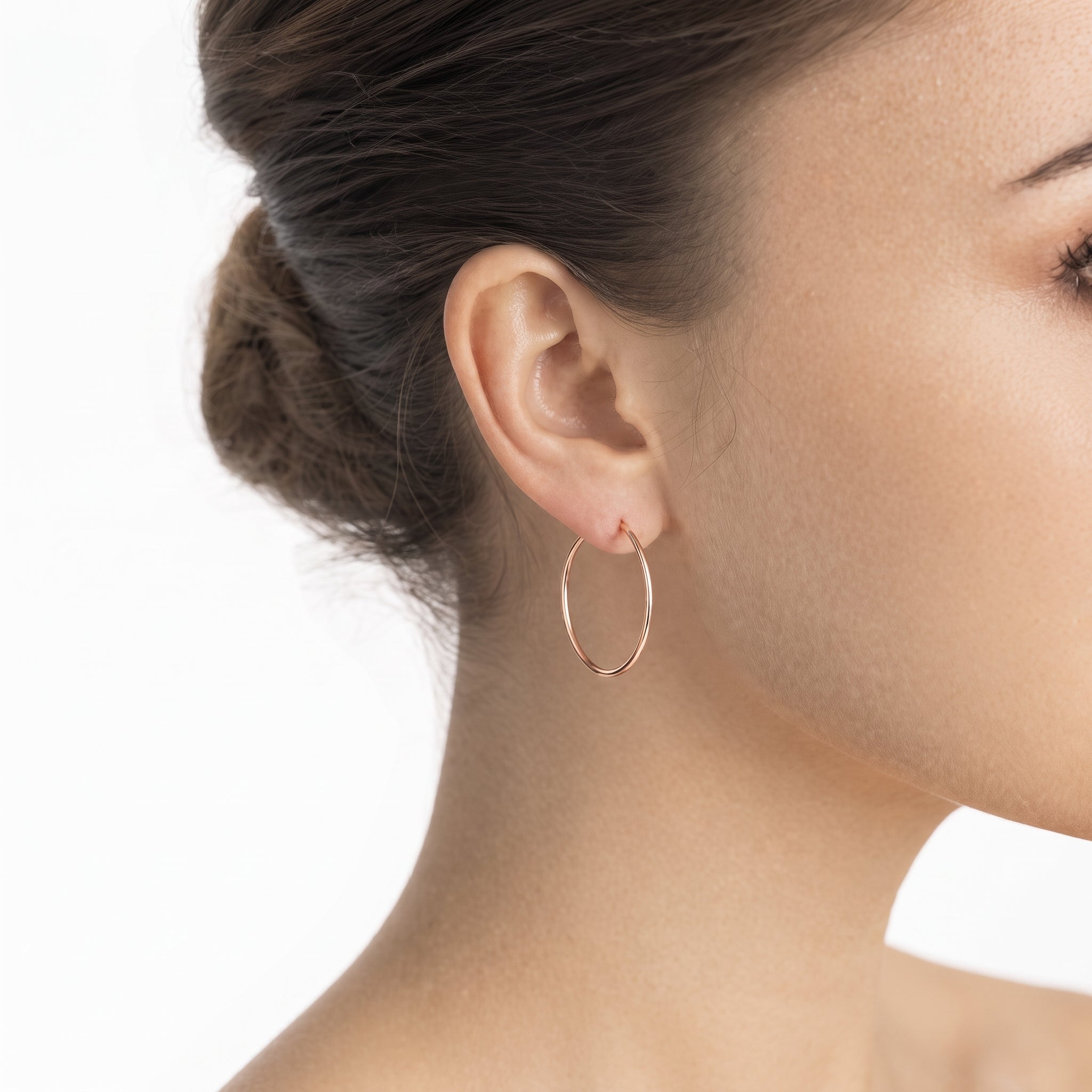 Sterling silver rose gold hoops worn in ear