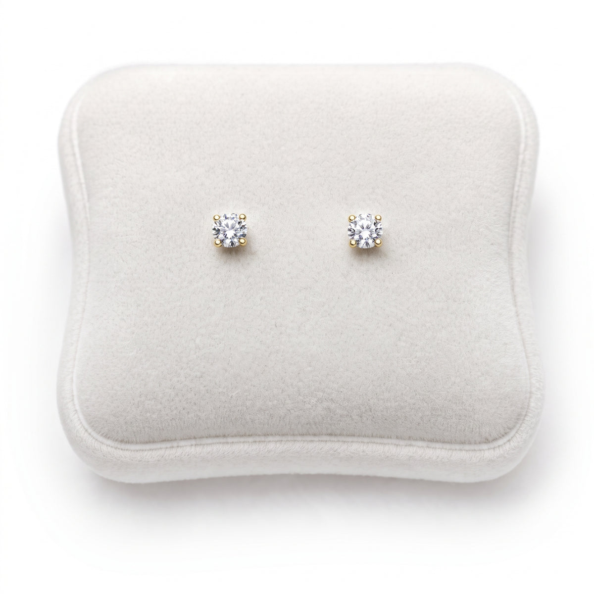 14k yellow gold clear round CZ earrings on Jewelery cushion