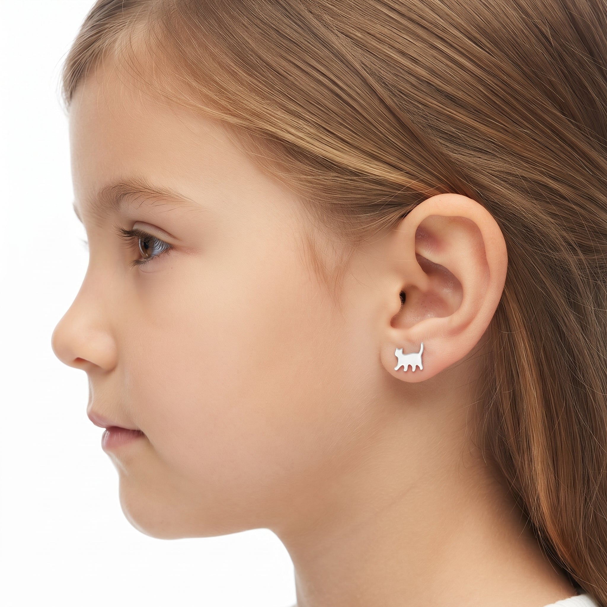 A close-up side profile of a young girl wearing a small silver stud earring shaped like a cat silhouette, against a clean white background.