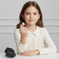 Girl wearing an adjustable unicorn ring for kids from Melchior Jewellery sitting at a white table with branded black box