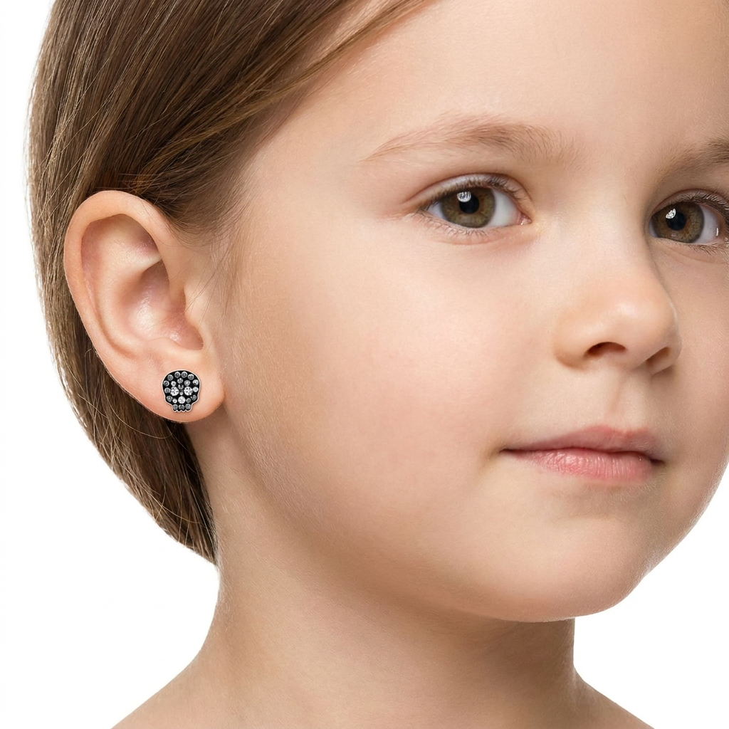 Sterling silver crystal skull stud earring worn by a child, showing size and fit by Melchior Jewellery
