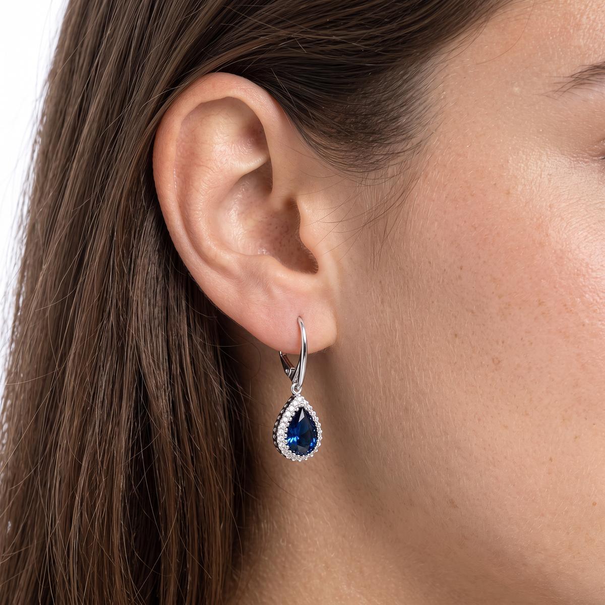 Close-up of blue sapphire teardrop earrings with sterling silver setting