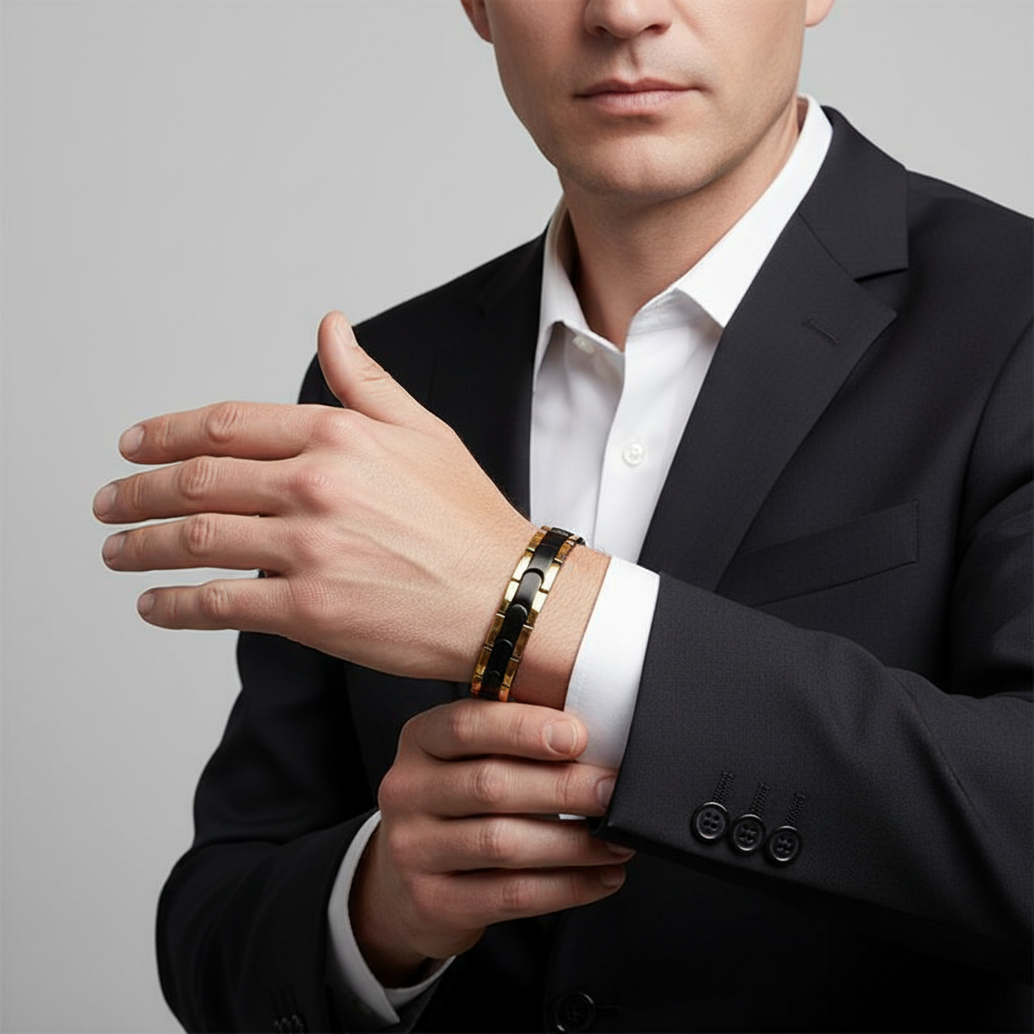 Melchior Jewellery black gold magnetic bracelet worn on wrist with black suit and white shirt