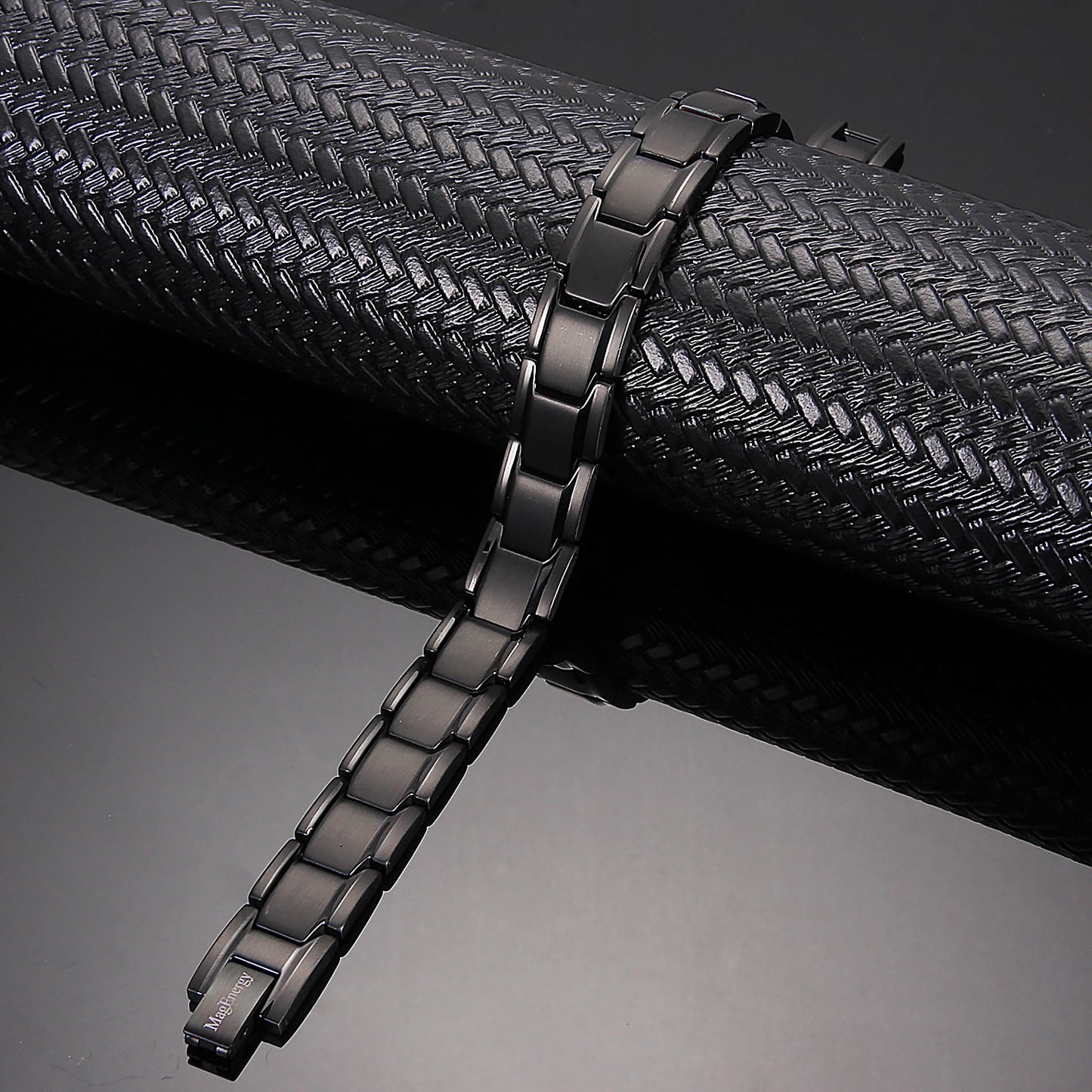 Melchior Jewellery black titanium magnetic bracelet with sleek matte black links on textured black surface