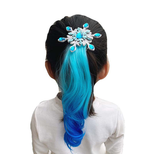 Blue synthetic hair extension for girls clipped into dark hair with decorative blue and silver accessory