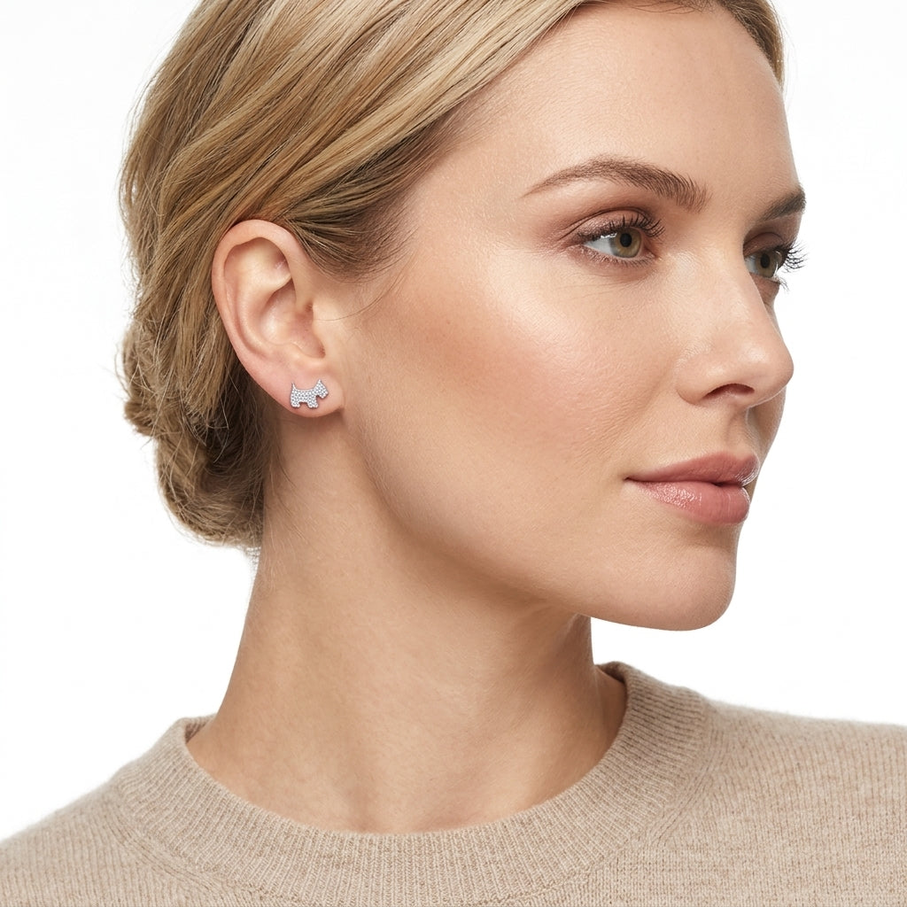 Melchior Jewellery Scottie Dog Pave Stud Earrings in silver worn by woman with blonde hair and beige sweater