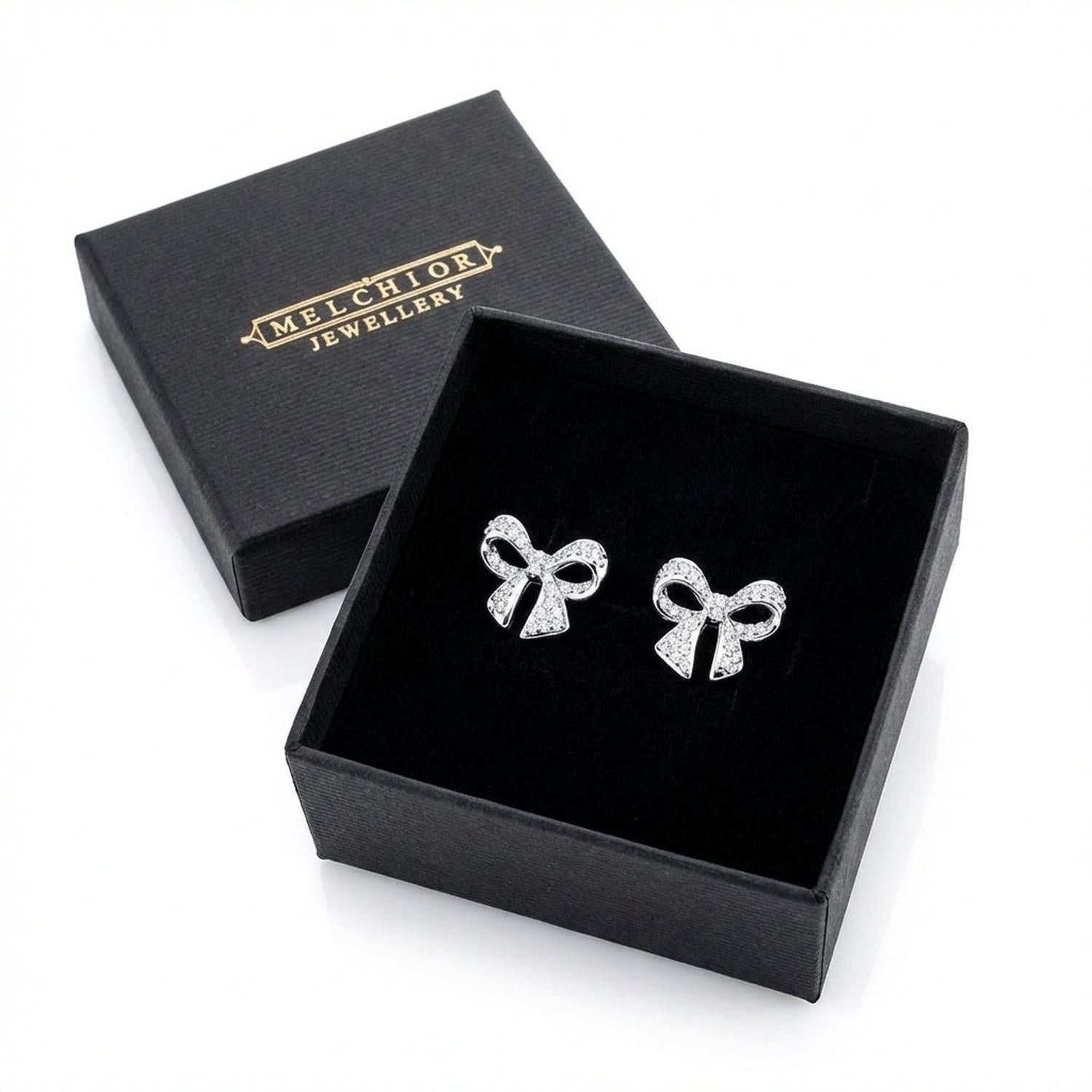 Sentiell sterling silver bow stud earrings displayed in a black Melchiory Jewellery box