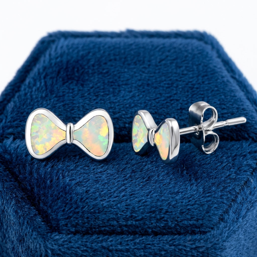 Melchior Jewellery Opal Bow Stud Earrings with iridescent opal set in polished silver on navy blue velvet