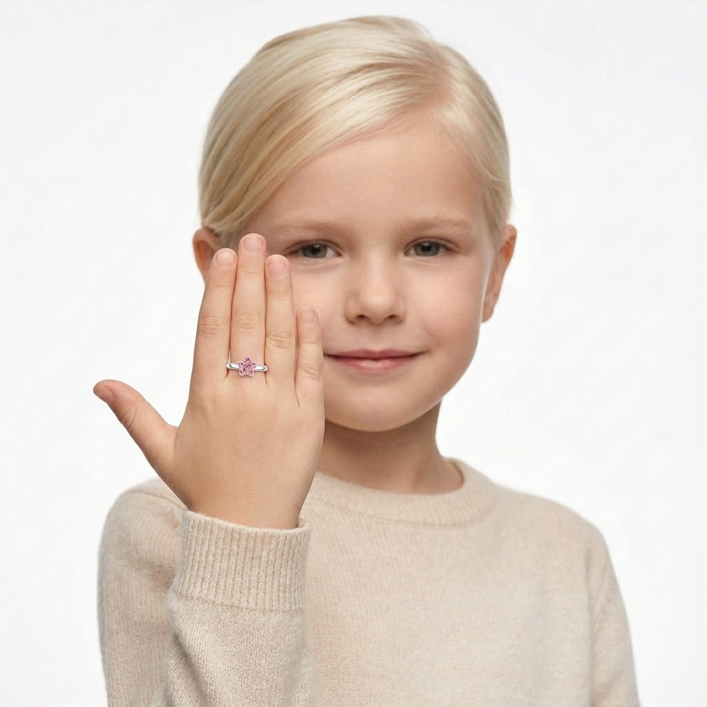 Young girl wearing a Melchior Jewellery girls star ring with a pink star-shaped gemstone on silver band