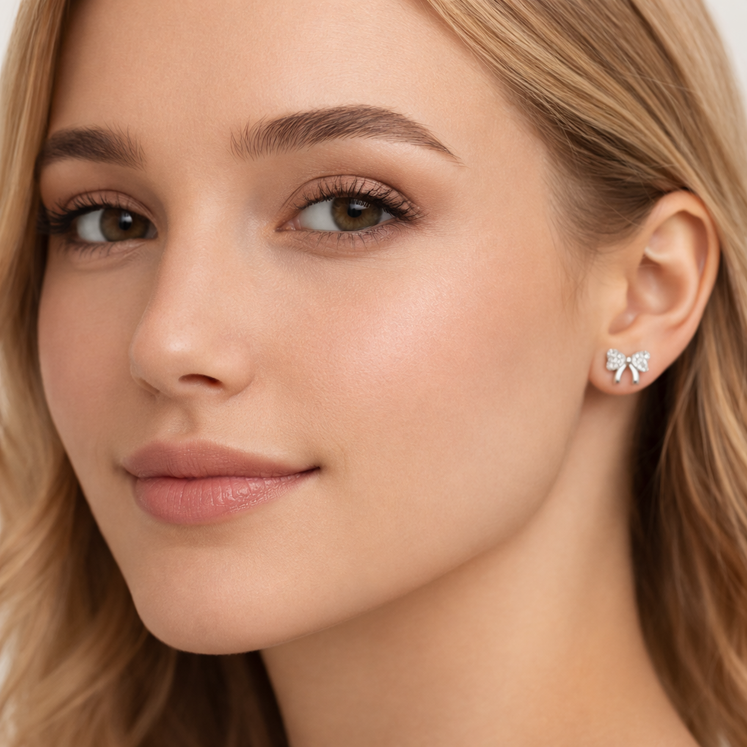 Melchior Jewellery sterling silver bow stud earrings worn by woman with light skin and blonde hair