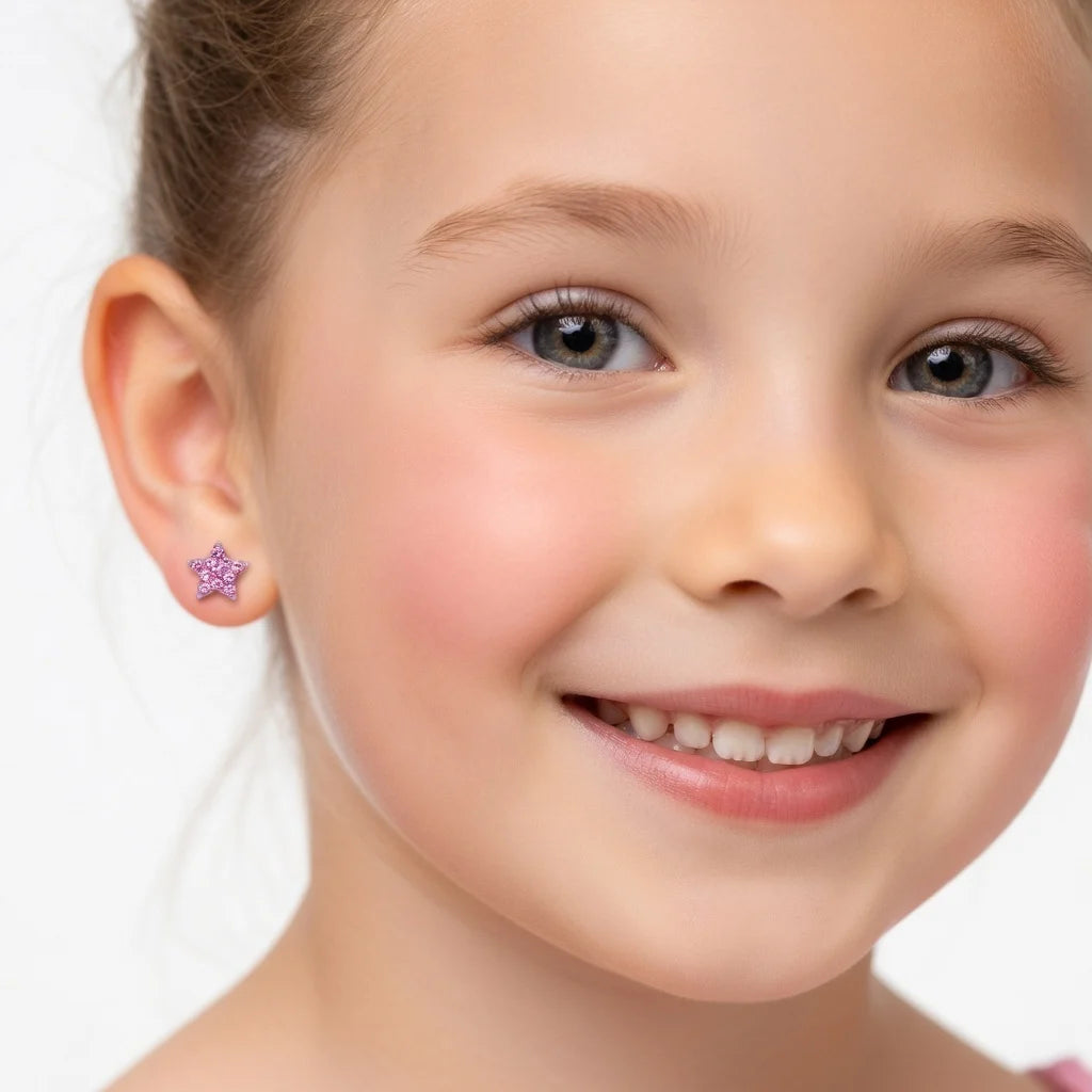 A close-up of a young girl's face showing a small, sparkling purple star-shaped stud earring on her earlobe, set against a clean white background.