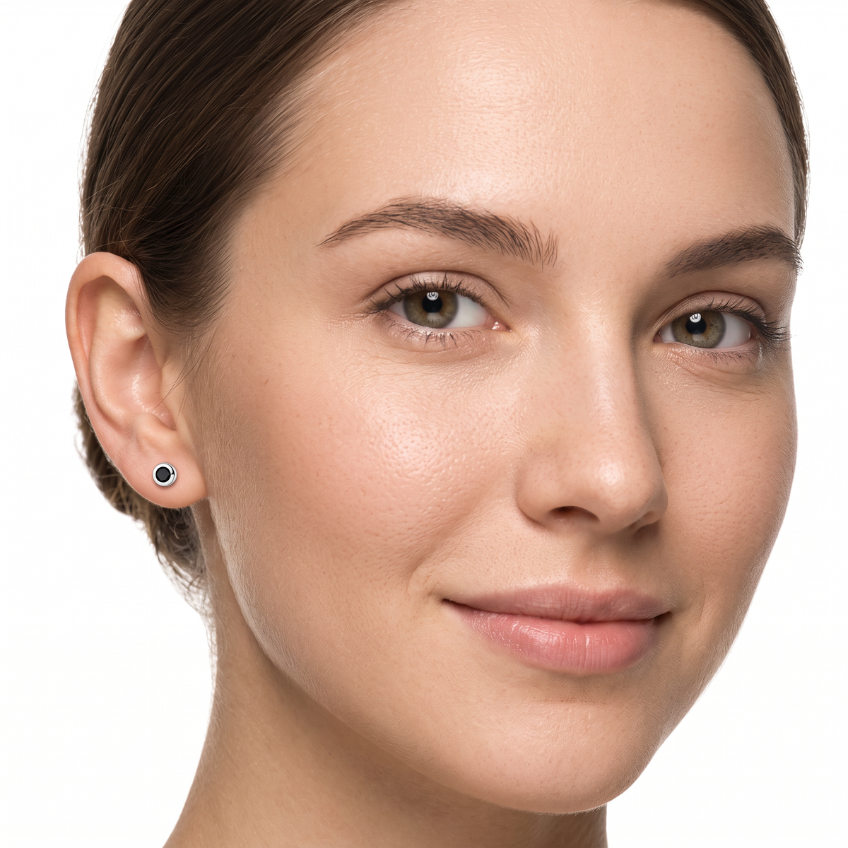 Close-up of a woman's face wearing a small round stud earring with a  black stone in a silver setting
