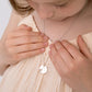 Child wearing Melchior Jewellery children's personalised heart necklace with engraved name on silver pendant