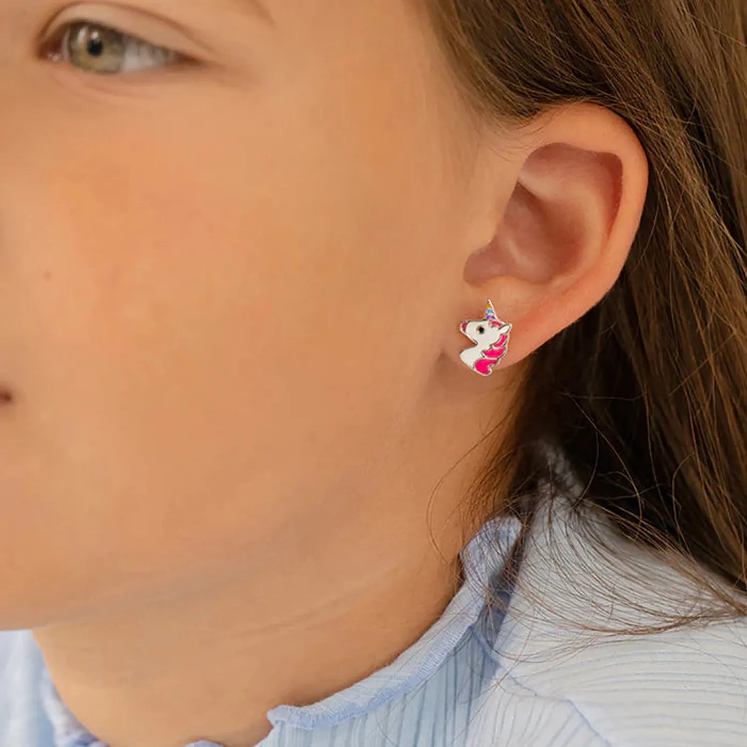 sterling silver childrens unicorn earrings with pink and white enamel details worn by child