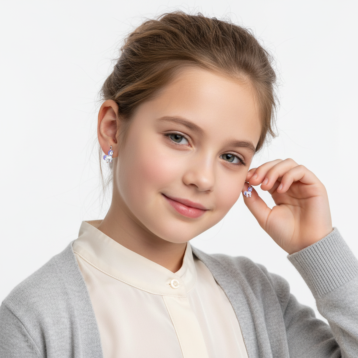 Silver unicorn drop earrings for girls by Melchior Jewellery worn by a smiling young girl