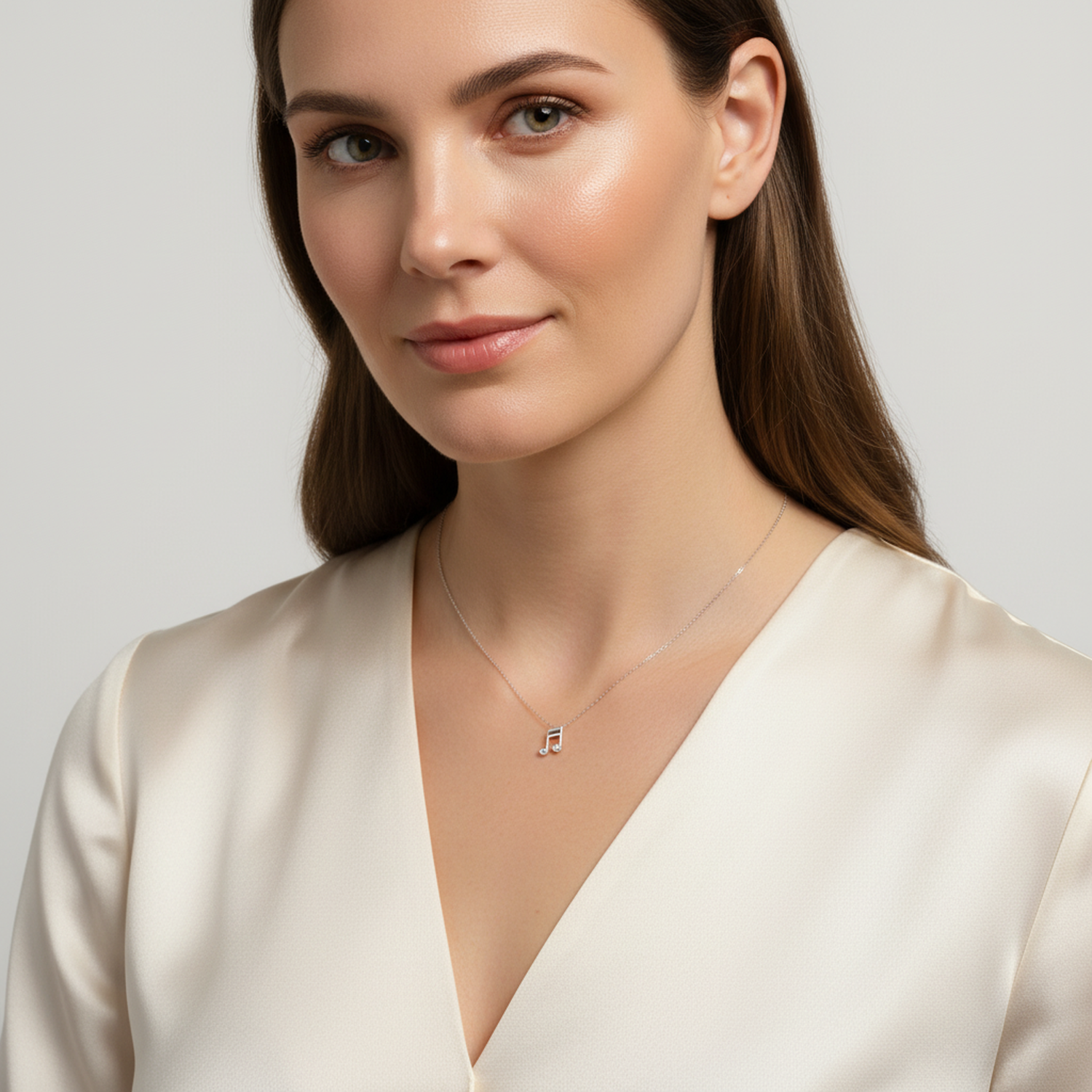 Elegant sterling silver music note necklace worn by woman with cream blouse from Melchior Jewellery