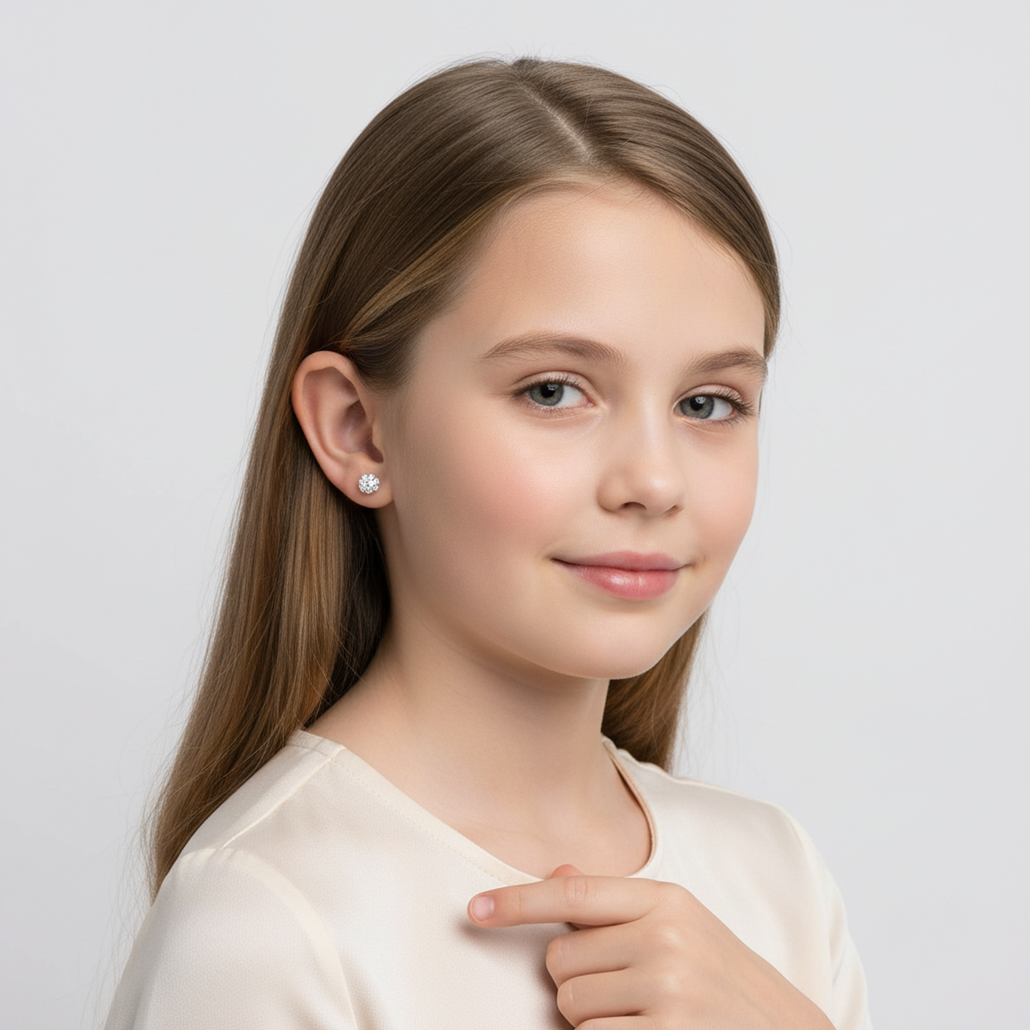 Young girl wearing sterling silver girls crystal stud earrings from Melchior Jewellery in a white top