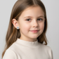Child wearing Melchior Jewellery football themed earrings for boys and girls with black and white football design
