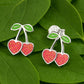 Melchior Jewellery girls silver cherry earrings with red heart-shaped cherries and green leaves on silver stems